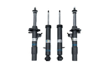 Load image into Gallery viewer, Four black automotive shock absorbers and struts arranged vertically on a plain white background, with silver and blue branding labels visible on the cylinders.