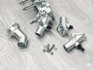 Supertec Racing billet water outlet for the Nissan RB26 engine. Machined from billet 6082 aluminium with auxiliary port and supplied with AN6-9/16 fitting or 3/8 barb or blank plug (turbo water return) or blank plugged for use with turbos that are not water cooled. 
